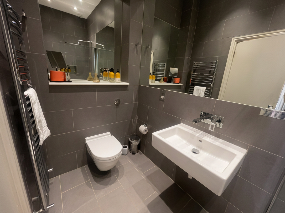 Hastings House Bedroom 3 ensuite — dark grey tiled shower room with large mirror