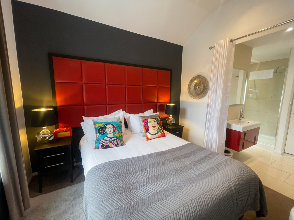 Hastings House Bedroom 1 — red headboard with ensuite shower room