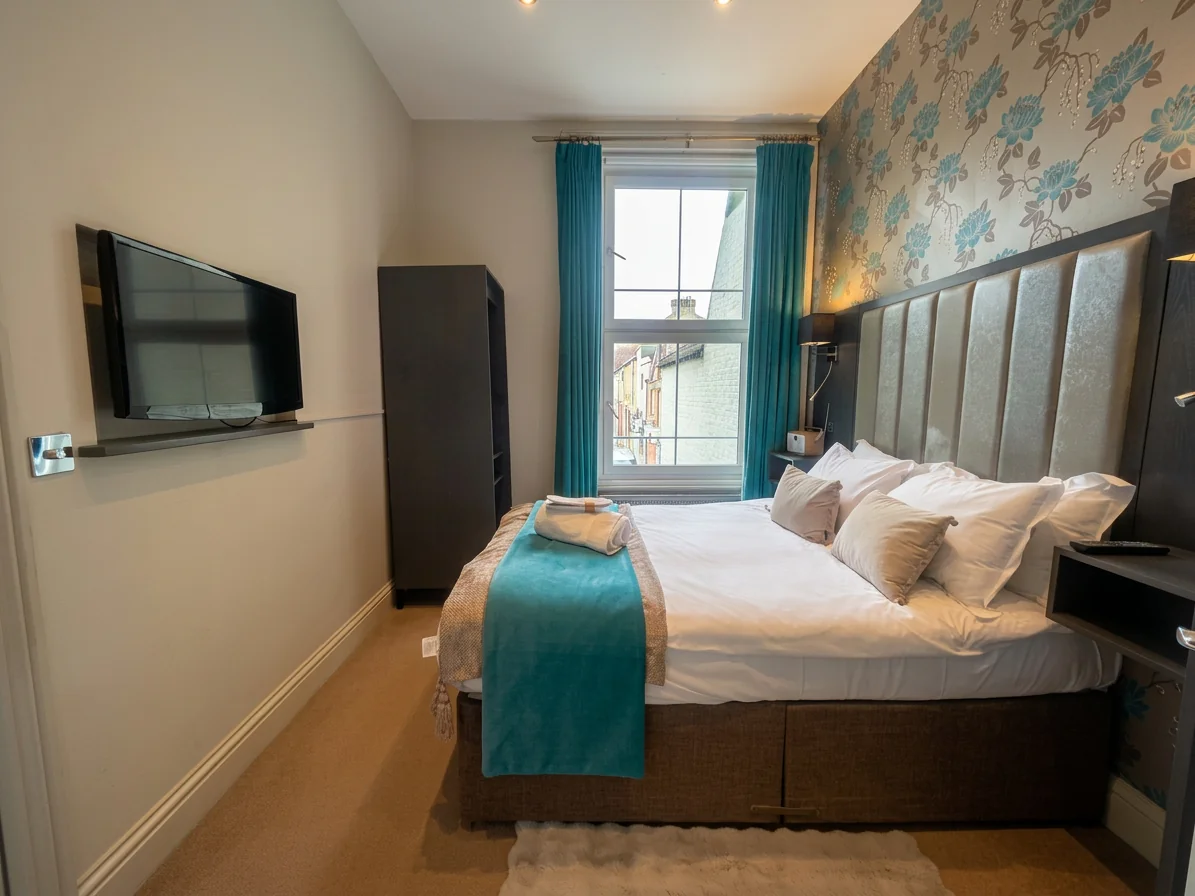 Hastings House Bedroom 2 — wide angle with TV and wardrobe