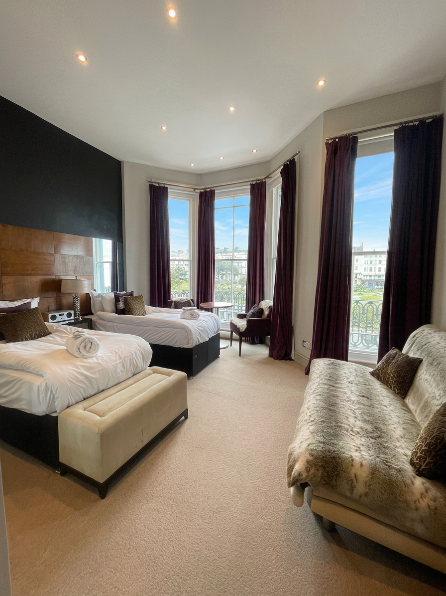 Hastings House Bedroom 3 — twin configuration with sofa and sea views