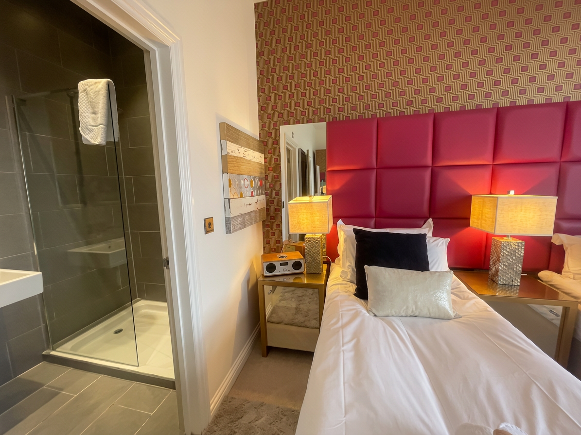 Hastings House Bedroom 7 — sea view sitting area with red leather armchairs and Hastings pier