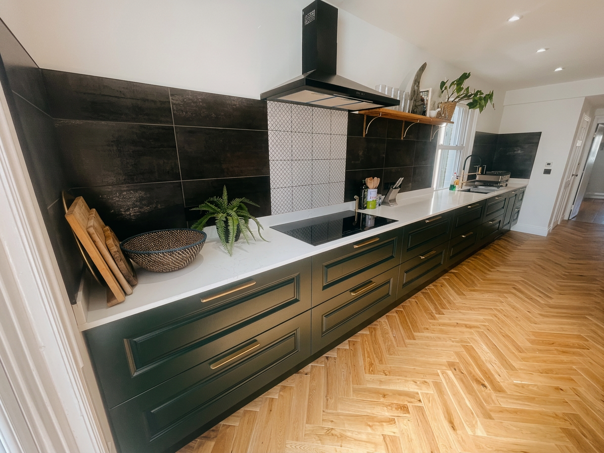 Hastings House kitchen from back — green cabinetry, induction hob and herringbone floor