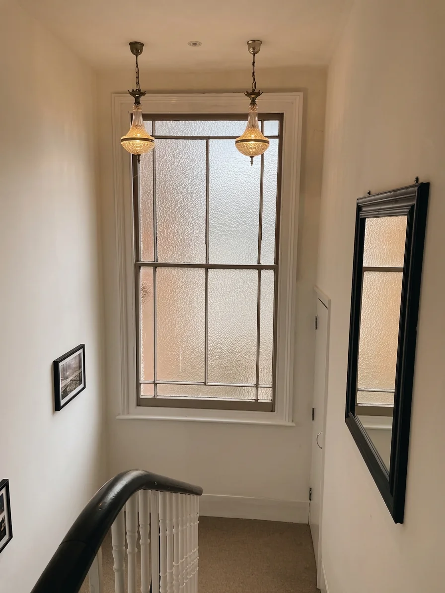Hastings House landing with two brass pendant lights and large sash window